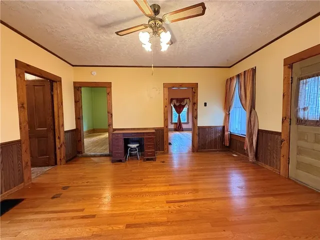 an empty room with wooden floor and windows