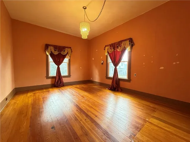 an empty room with fan and windows