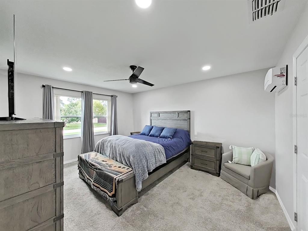 8527 Jolly Roger Drive Hudson, FL 34667 - Photo 11 of 39 a spacious bedroom with a bed and a couch