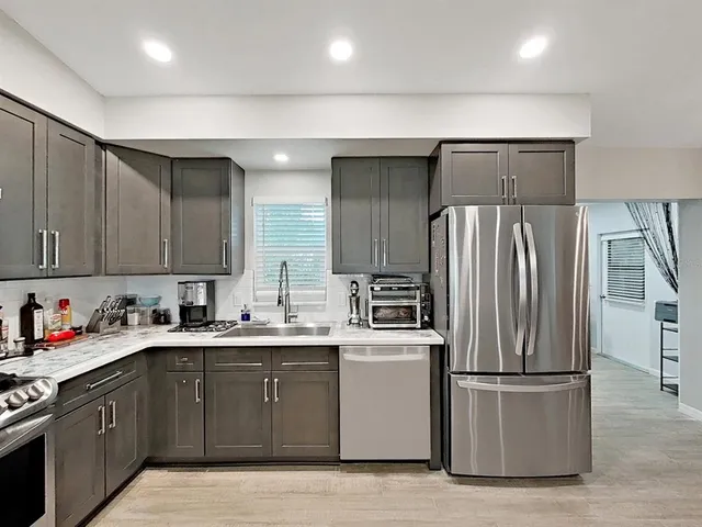 a kitchen with a sink a refrigerator and cabinets