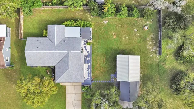 an aerial view of a house with a yard and lake view