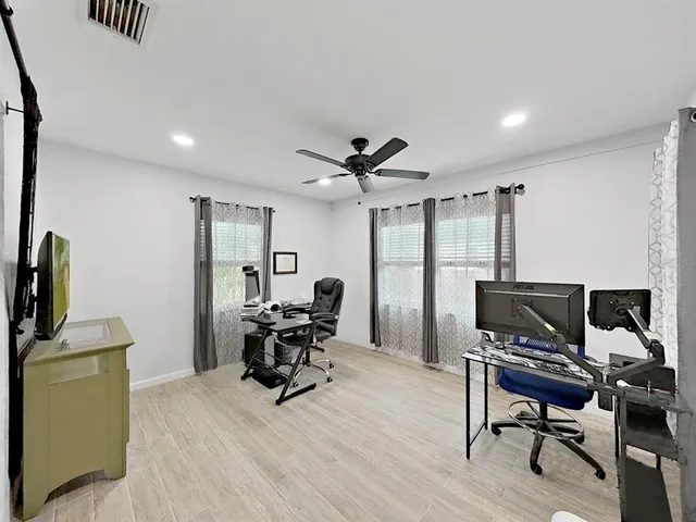 a work room with furniture and a flat screen tv