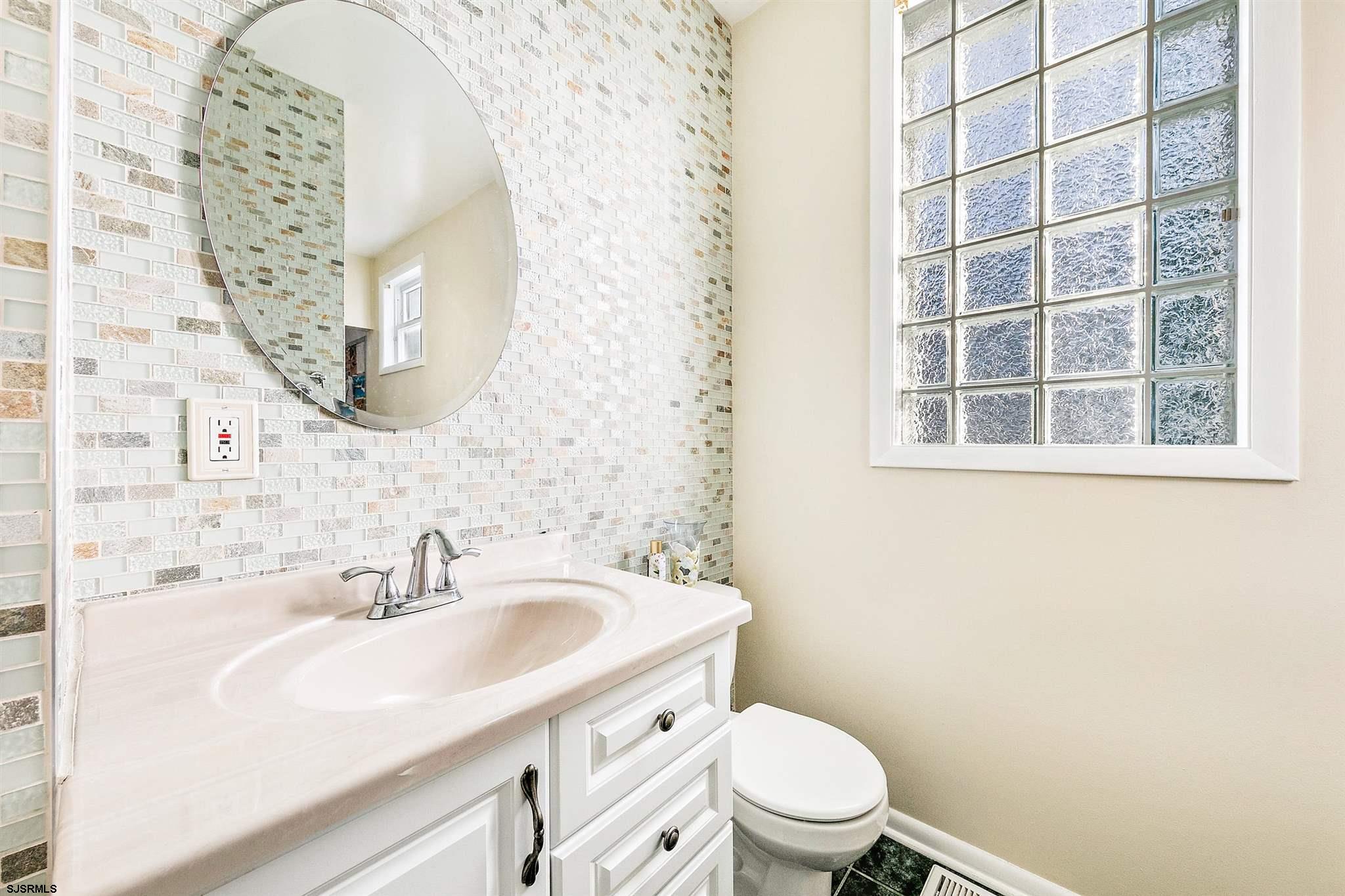 1401 Shore Road Northfield, NJ 08225 - Photo 67 of 96 a bathroom with a sink a toilet and a mirror