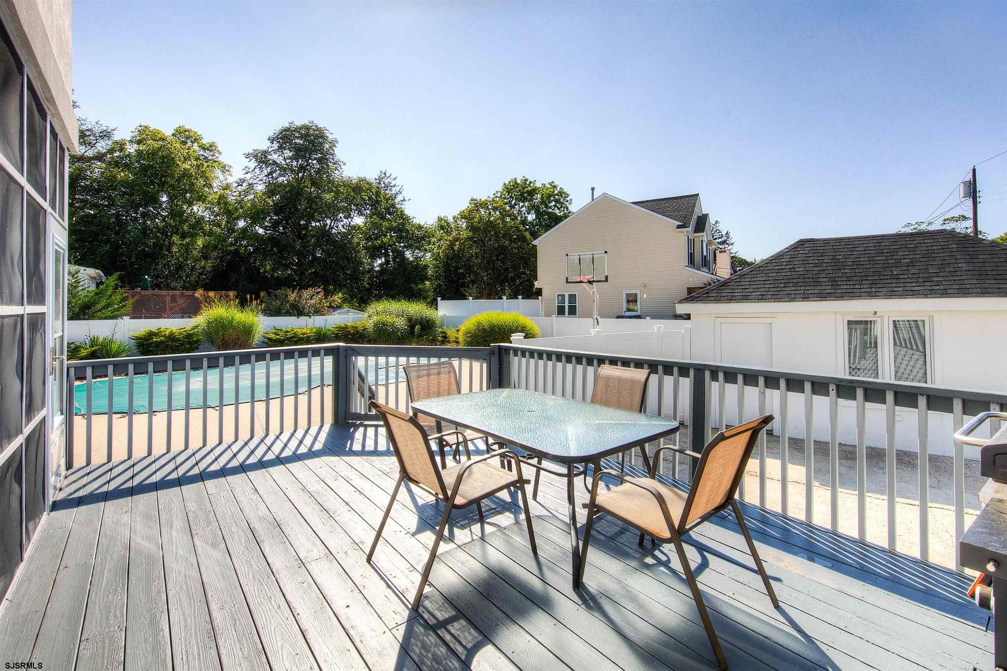 1401 Shore Road Northfield, NJ 08225 - Photo 76 of 96 a view of a roof deck with table and chairs a barbeque with wooden floor and fence