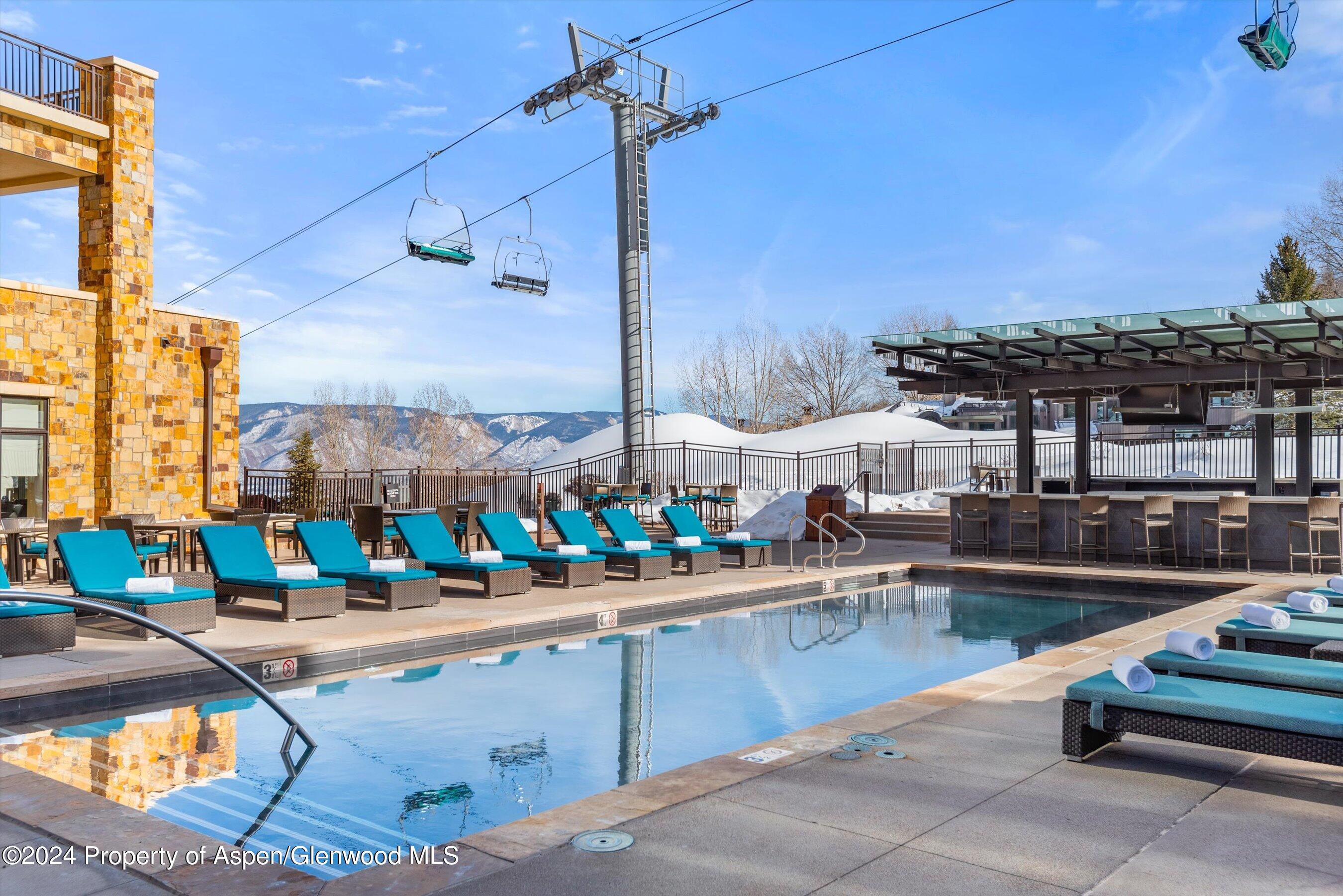 130 Wood Road, Unit 504 Snowmass Village, CO 81615 - Photo 15 of 20 a view of a swimming pool with outdoor seating
