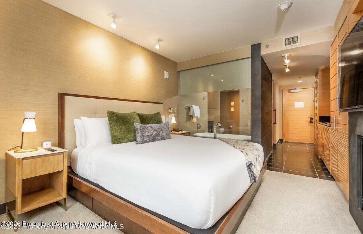 130 Wood Road, Unit 504 Snowmass Village, CO 81615 - Photo 3 of 20 a bedroom with a bed and a chandelier