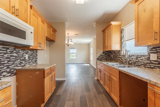 a kitchen with stainless steel appliances granite countertop a stove a sink and a microwave