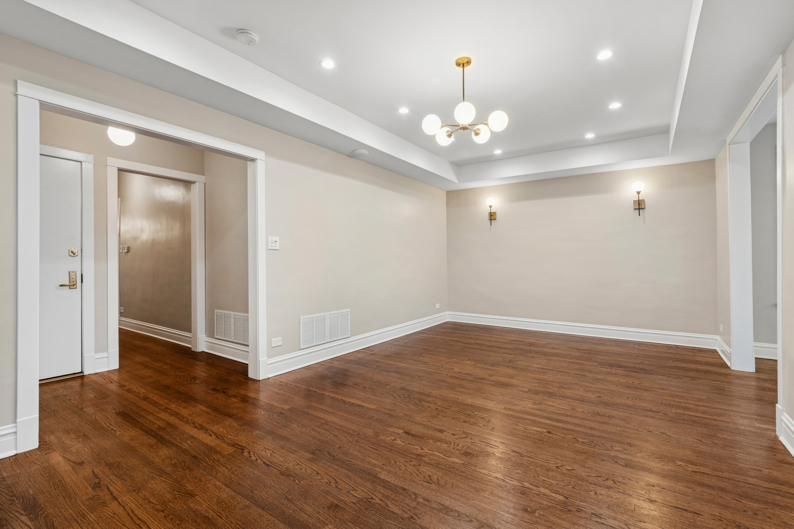 4932 North Ridgeway Avenue, Unit 2 Chicago, IL 60625 - Photo 3 of 21 a view of an empty room with wooden floor and chandelier