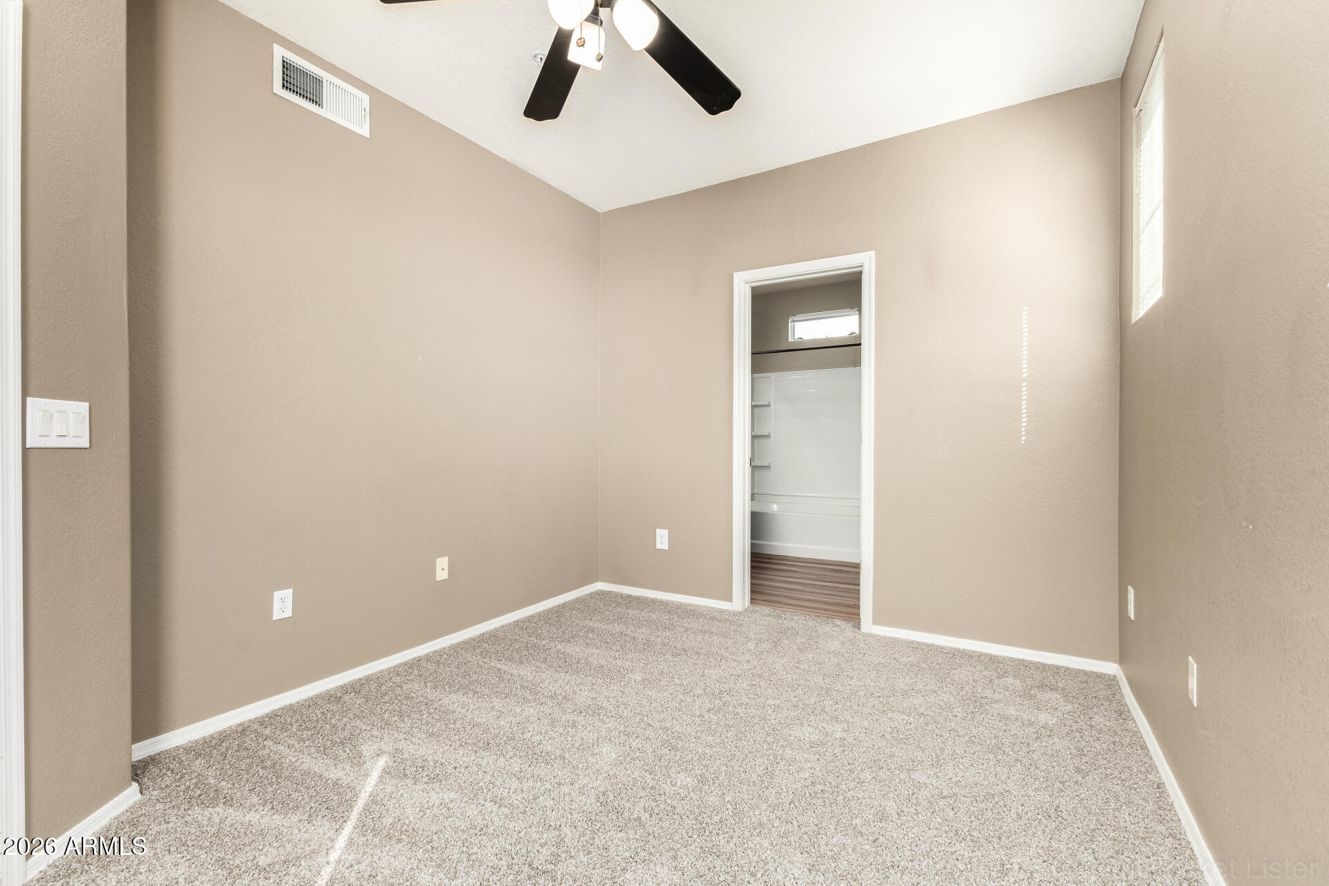 18250 North Cave Creek Road, Unit 198 Phoenix, AZ 85032 - Photo 11 of 30 an empty room with ceiling fan and window