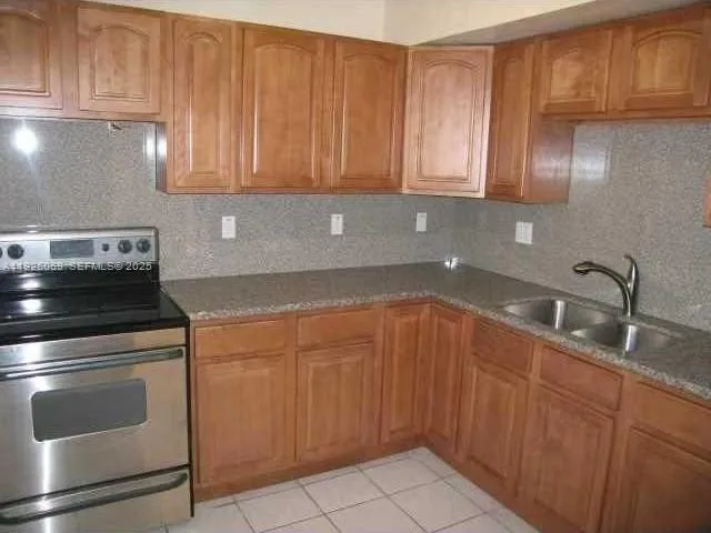 a kitchen with granite countertop cabinets stainless steel appliances and a sink