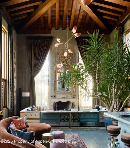 a living room with furniture a fireplace and a potted plant