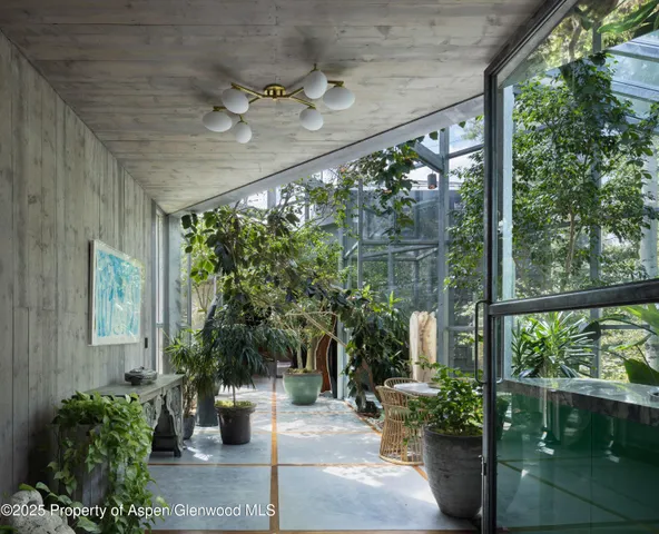a view of a porch with chairs and potted plants
