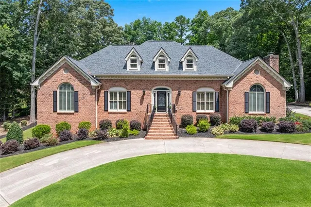 a front view of a house with a garden and plants