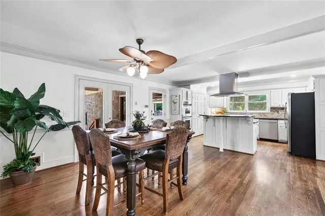 a kitchen with stainless steel appliances a stove a refrigerator and wooden floor
