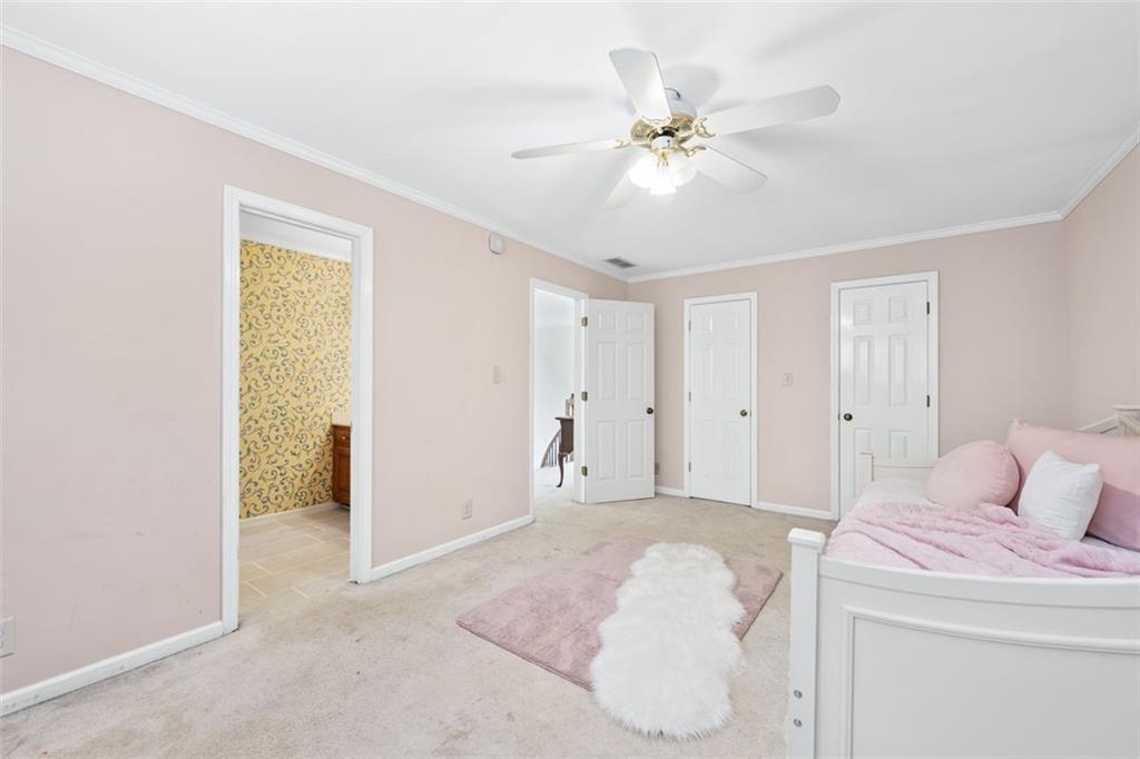 2065 Innsfail Drive Snellville, GA 30078 - Photo 32 of 71 a bedroom with a bed and a chandelier fan