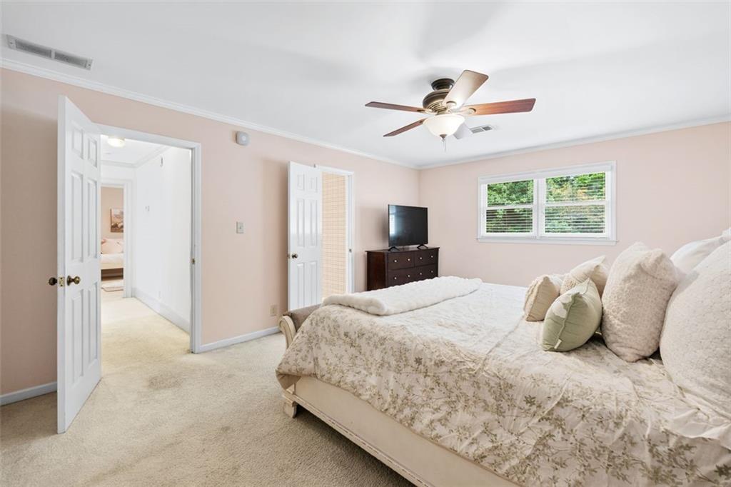 2065 Innsfail Drive Snellville, GA 30078 - Photo 34 of 67 a bedroom with a large bed and a chandelier fan