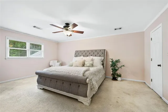 a spacious bedroom with a bed and a chandelier
