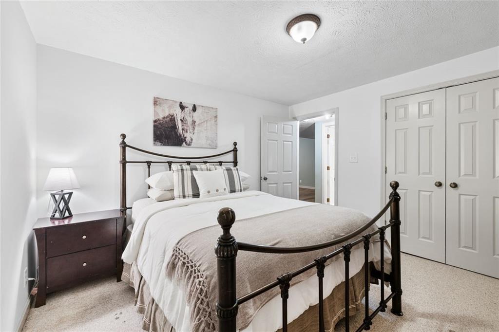 2065 Innsfail Drive Snellville, GA 30078 - Photo 46 of 67 a bedroom with a bed and a chandelier