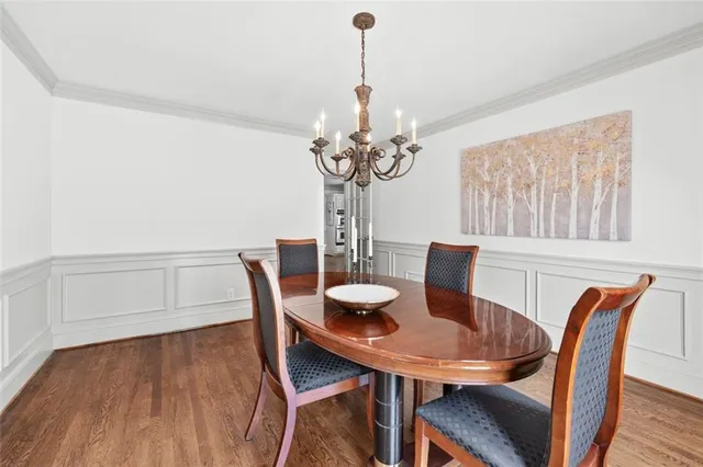 a dining room with furniture wooden floor a rug and a chandelier