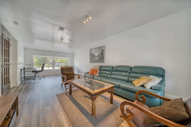 a living room with furniture and wooden floor