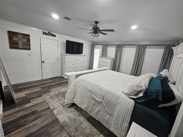 a spacious bedroom with a bed and a flat screen tv