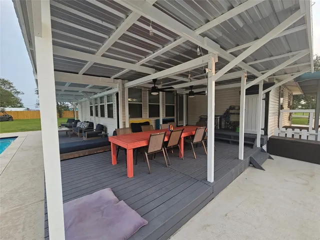 a view of a porch with dining table and chairs with wooden floor and fence