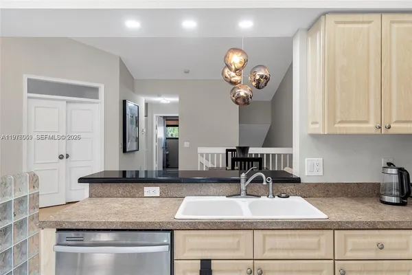 a kitchen with kitchen island granite countertop a sink a stove and cabinets