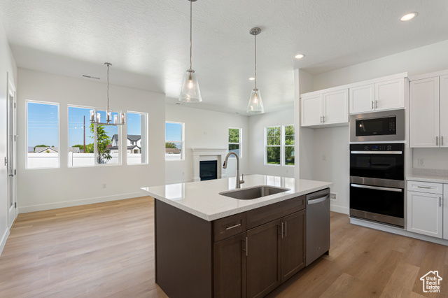 549 North Legend Circle, Unit C/466 Mapleton, UT 84664 - Photo 15 of 39 Kitchen with light wood finished floors, appliances with stainless steel finishes, a textured ceiling, white cabinets, and recessed lighting