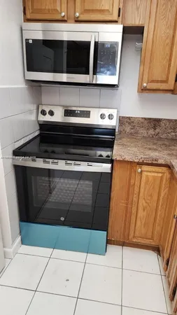 a kitchen with granite countertop a stove and a microwave
