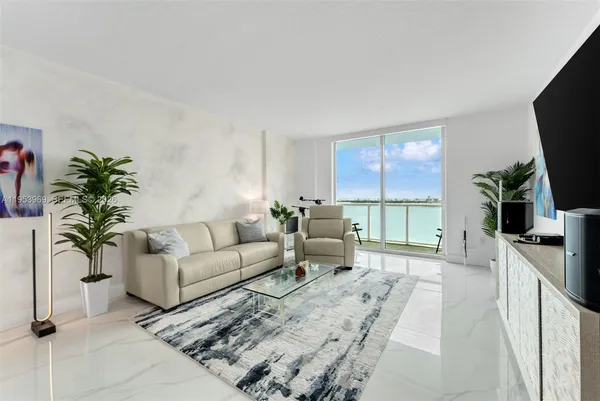 a living room with furniture a flat screen tv and a floor to ceiling window