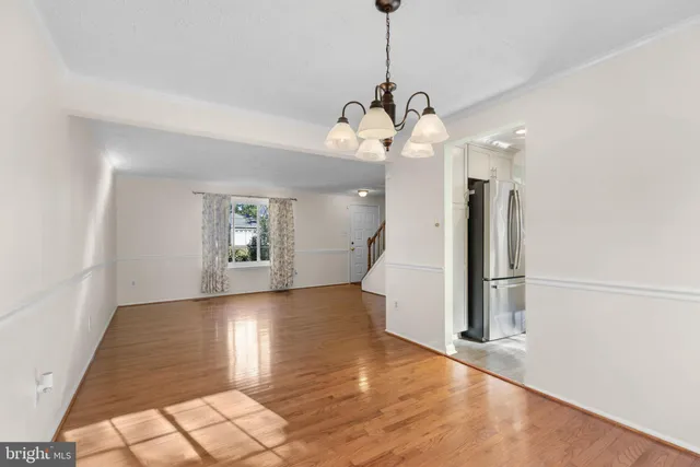 a view of a room with wooden floor chandelier and entryway