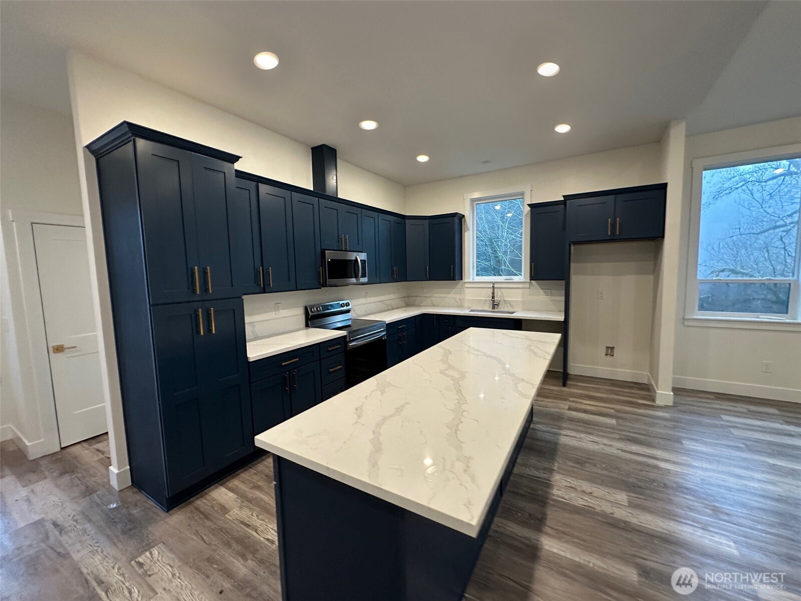 559 Upper Naselle Road Naselle, WA 98638 - Photo 11 of 32 a kitchen with kitchen island granite countertop wooden cabinets a refrigerator and a sink