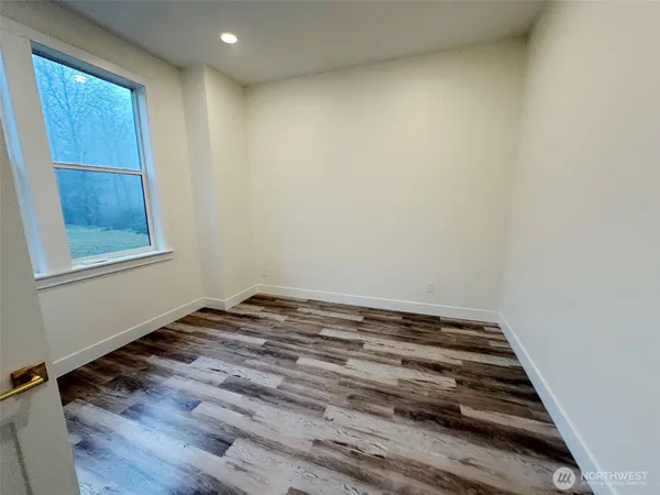 a room with a wooden floor and a window