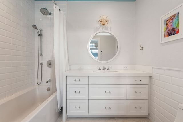 a bathroom with a tub sink double vanity and mirror