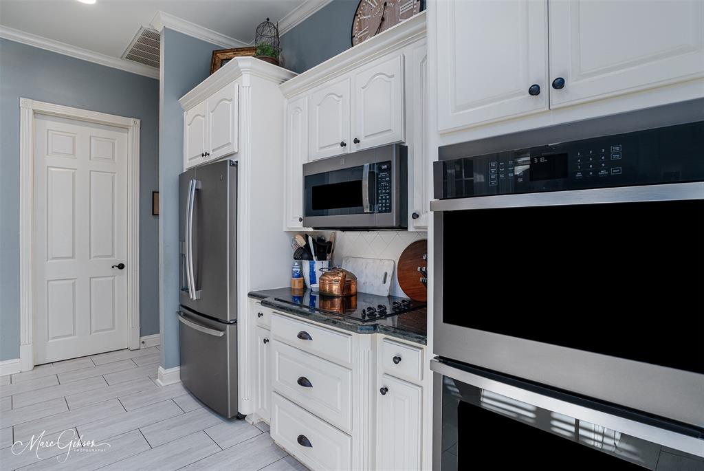 1310 Bay Ridge Drive Bossier City, LA 71111 - Photo 14 of 37 a kitchen with stainless steel appliances a refrigerator stove and white cabinets