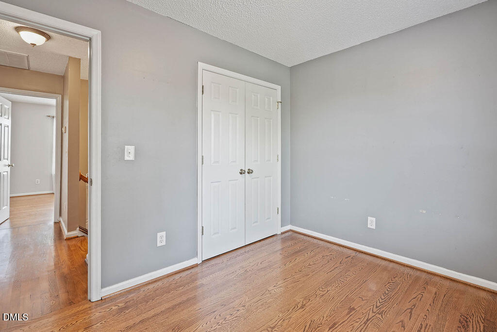 1560 Cane Mill Road Coats, NC 27521 - Photo 17 of 32 a view of an empty room with wooden floor and a hallway