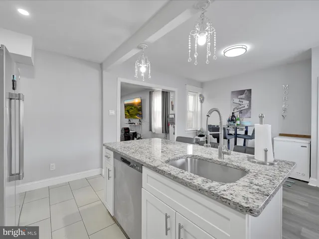 a kitchen with granite countertop a sink a counter top space and cabinets