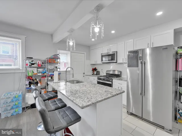 a kitchen with granite countertop stainless steel appliances a refrigerator and a stove top oven
