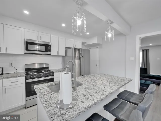 a kitchen with kitchen island granite countertop a stove oven and a sink