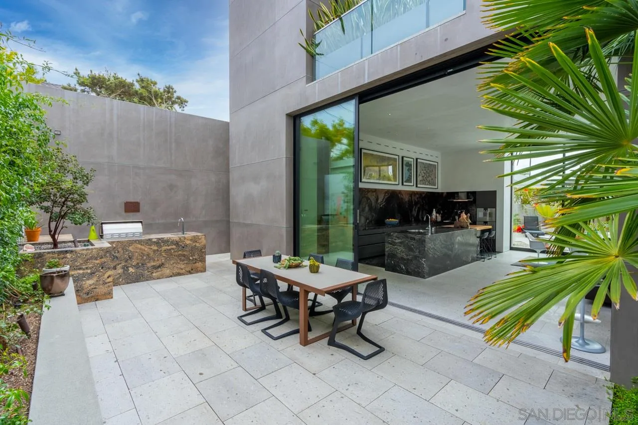 1228 Park Row La Jolla, CA 92037 - Photo 10 of 35 a view of a patio with table and chairs potted plants and a palm tree