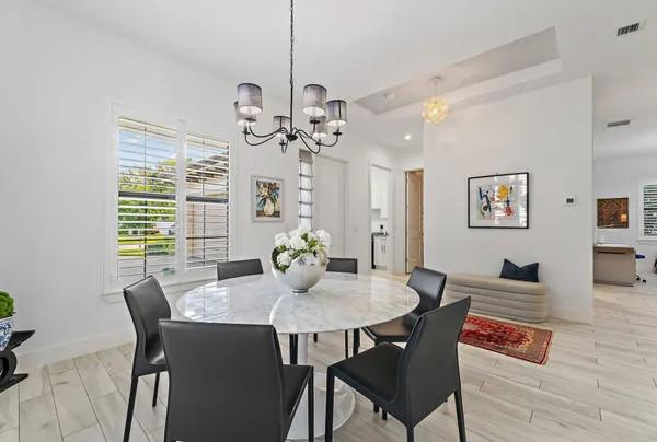 a kitchen with stainless steel appliances kitchen island granite countertop a table chairs and a refrigerator