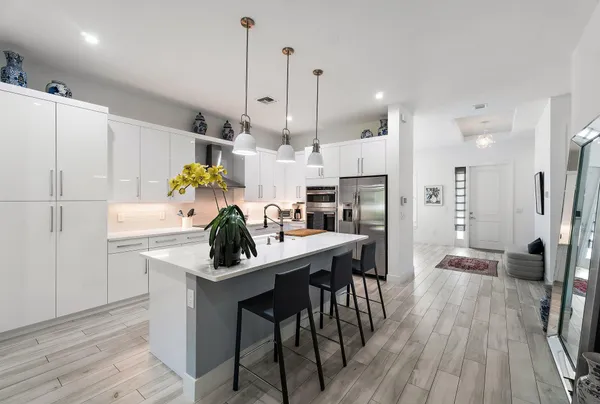 a kitchen with stainless steel appliances a sink a stove and a wooden floors