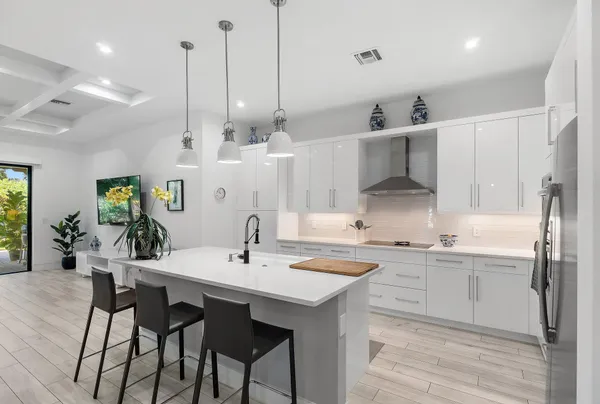 a large kitchen with kitchen island a large island a sink stainless steel appliances and wooden floor