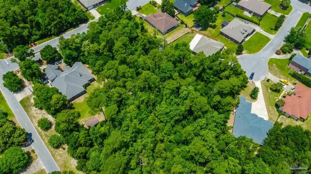 an aerial view of residential house with outdoor space and trees all around