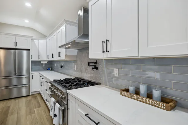 a living room with stainless steel appliances furniture and a flat screen tv