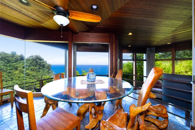 a patio with a table and chairs and potted plants