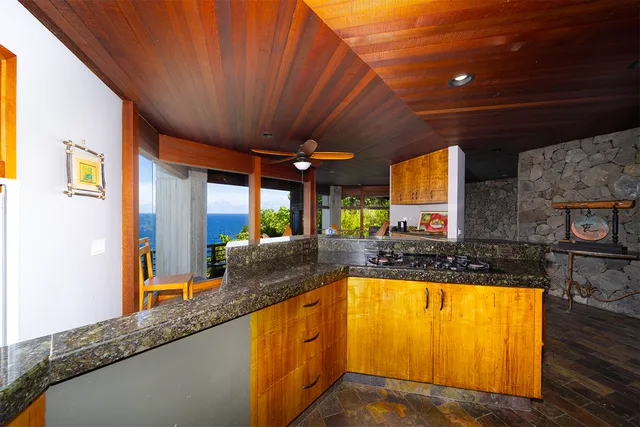 a view of a kitchen with a large window and wooden floor
