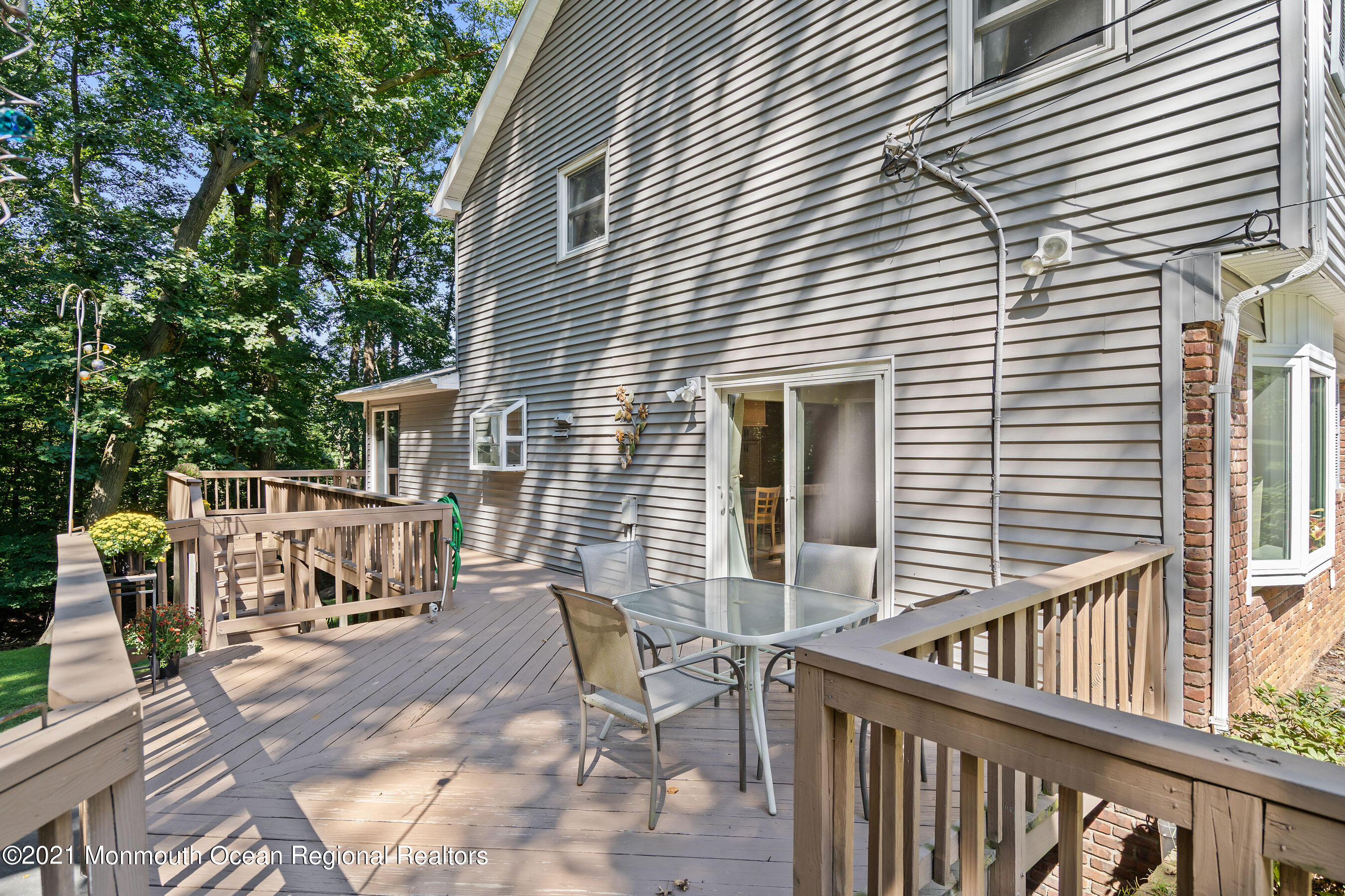 88 Beechwood Road Lincroft, NJ 07738 - Photo 27 of 33 a view of a patio with table and chairs with wooden floor and fence