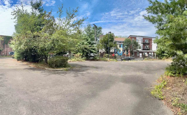 a view of street with a bench and trees