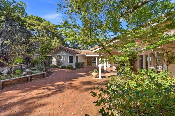 a front view of a house with a yard and potted plants